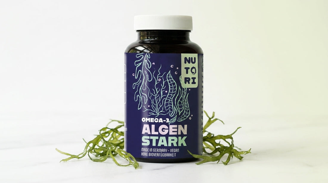 Nahaufnahme einer Flasche NUTORI ALGEN STARK mit veganen Omega-3 Kapseln aus Algenöl auf einem eleganten, minimalistischen Hintergrund mit frischen Algen.