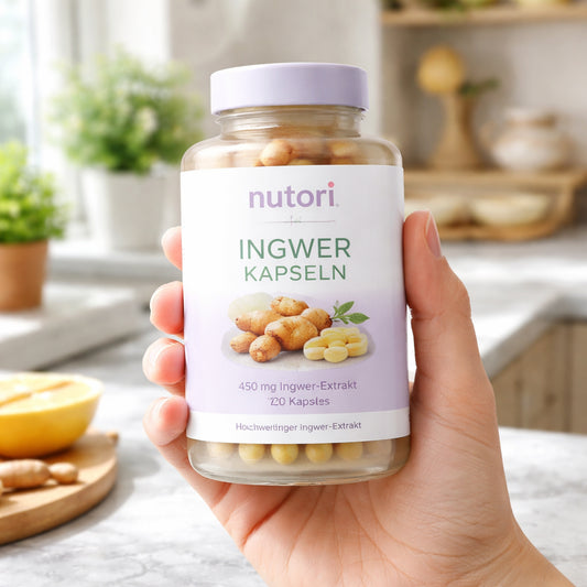 A photorealistic image of a hand holding a bottle of ginger capsules on a kitchen countertop, German packaging, natural lighting, showing the supplement label. Alt: Ingwer Kapseln kaufen – hochwertige Ergänzung in realistischer Darstellung